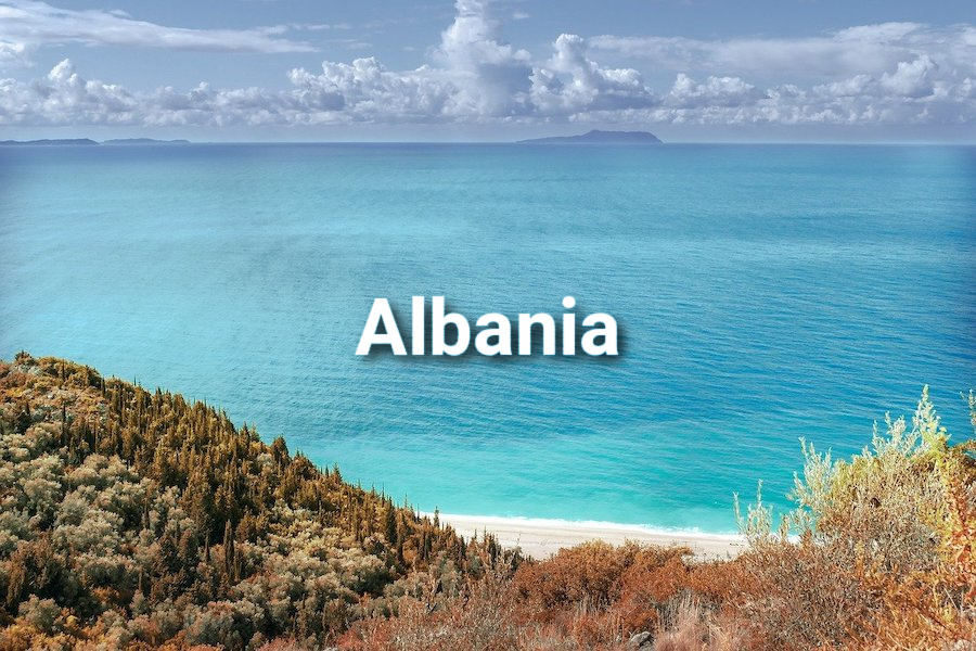 Looking down on a white sand beach with calm turquoise sea and the word Albania superimposed on top