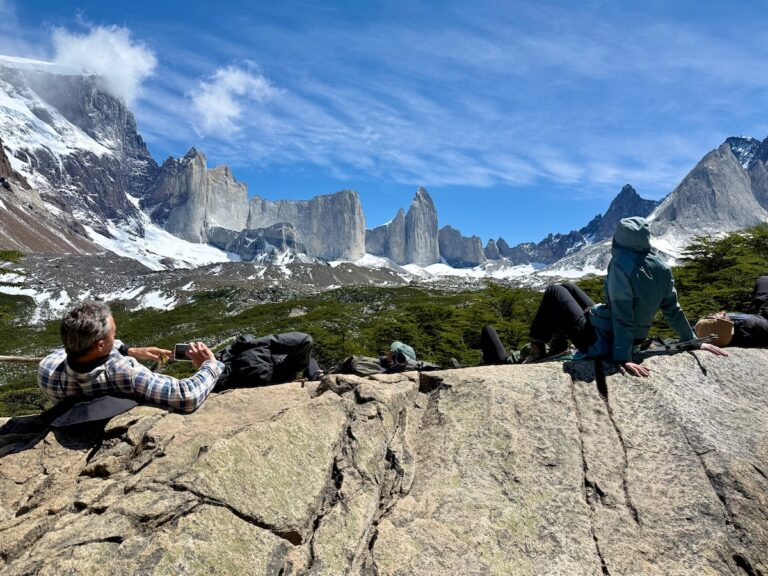 Hikers resting on rocks beneath the surrounding granite peaks at Mirador Británico in French Valley